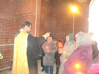 Окропление святой водой прихожан проводит отец Сергий.