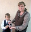 Первоклассник УСОШ № 1 Иван Шогенов первый получил светоотражающий маячок от своей первой учительницы Натальи Белышевой. Фото автора. «усольская газета»
