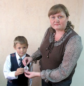 Первоклассник УСОШ № 1 Иван Шогенов первый получил светоотражающий маячок от своей первой учительницы Натальи Белышевой. Фото автора. «усольская газета»