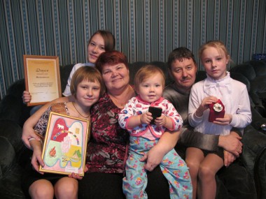 Слева направо: Света (с гербом семьи), Лиза (с дипломом), мама Лариса, внучка Элина, папа Николай и Саша.